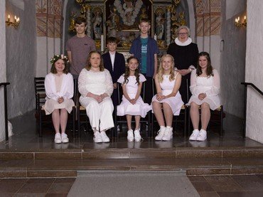 Præst og 8 konfirmander foran alteret i Auning Kirke